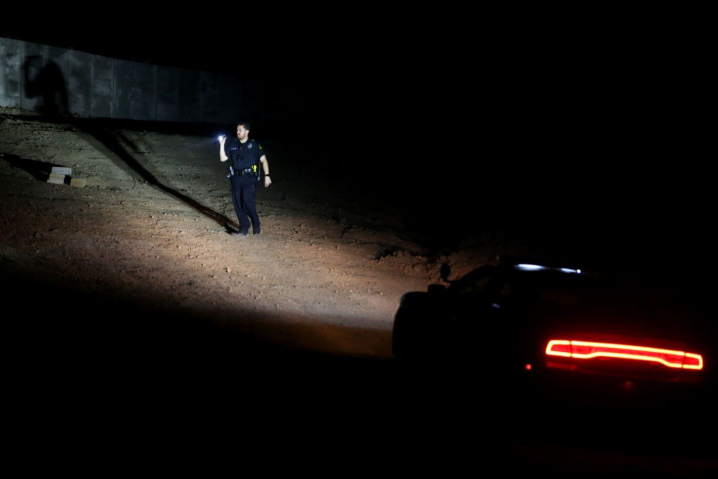 A Dallas Police officer searches an area Wednesday where Weltzin Garcia Mireles, 26, and...