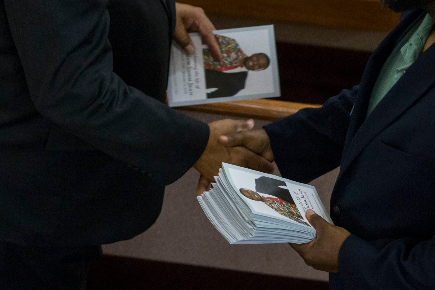 An usher shakes a mouners' hand after handing him a program before the funeral service for Botham Shem Jean at the Greenville Avenue Church of Christ on Thursday, September 13, 2018 in Richardson, Texas. He was shot and killed by a Dallas police officer in his apartment last week in Dallas. (Shaban Athuman/ The Dallas Morning News)