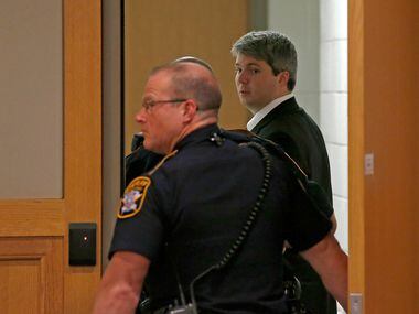 Defendant Jason Lowe (right) walks back to a holding cell with court deputies when the court...