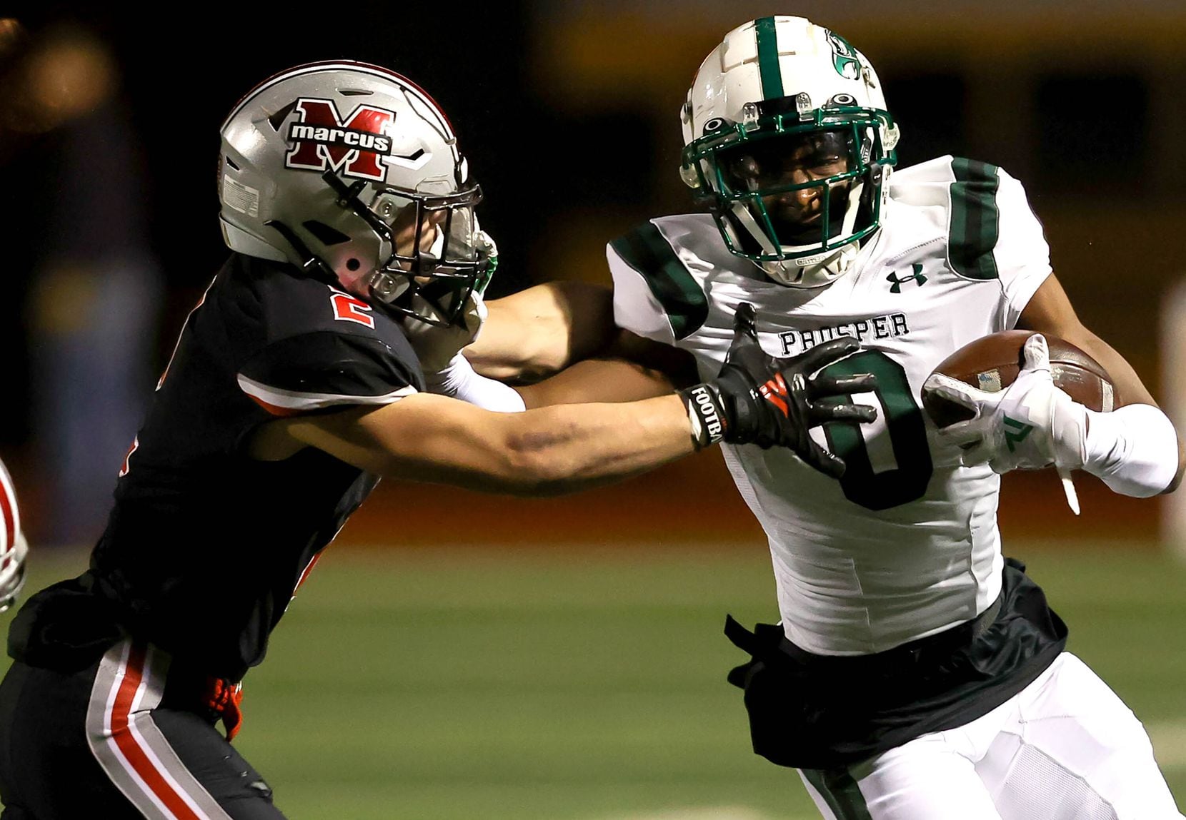 Prosper wide receiver Tyler Bailey (0) gives a stiff arm to Flower Mound Marcus defensive...