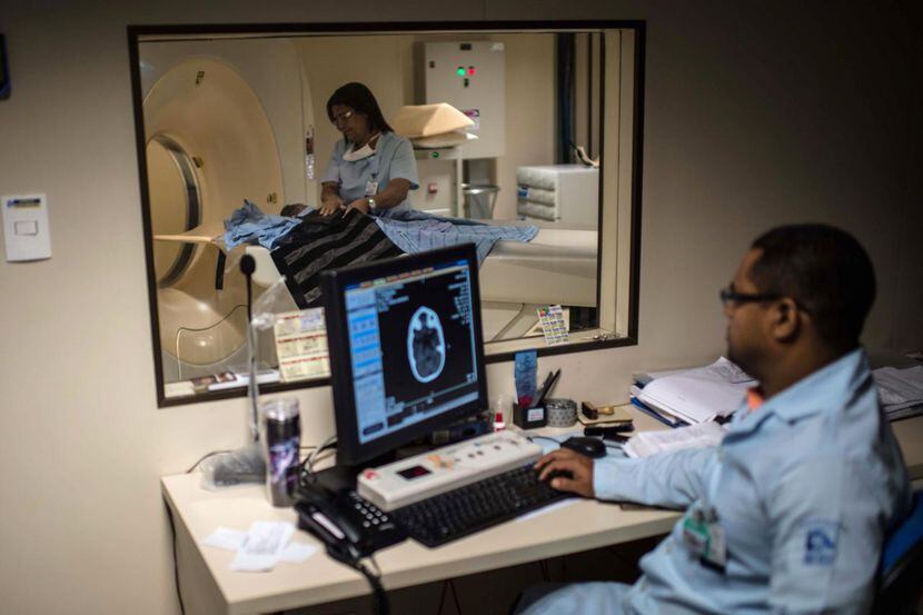 Un médico realiza una tomografía del cerebro de un recién nacido para detectar un posible...