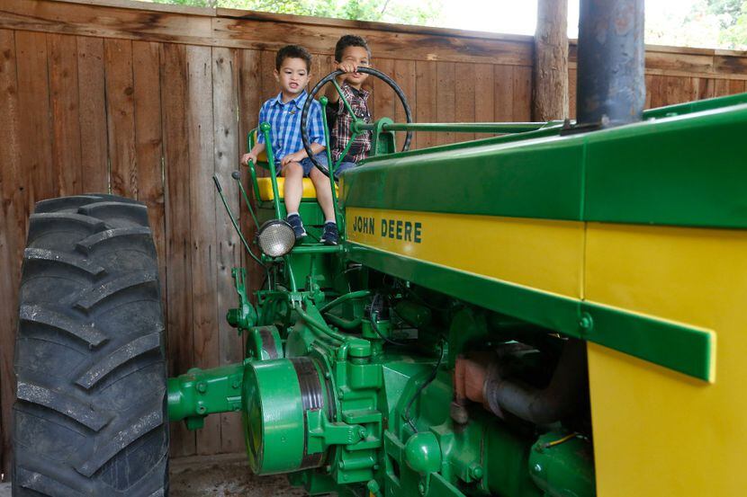 Sebastian Derry, 3, and his brother, Philip Derry, 5, of Keller, play on one of the tractors...