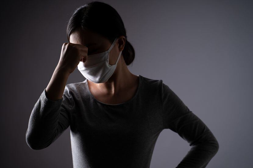 Una mujer porta una máscara protectora en su rostro.