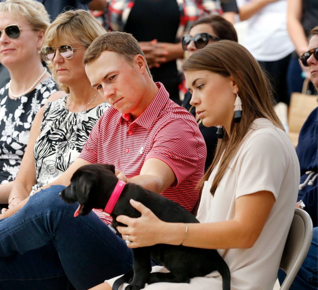 PGA golfer Jordan Spieth plays with he and his fiance Annie Verret's (right) new dog during...