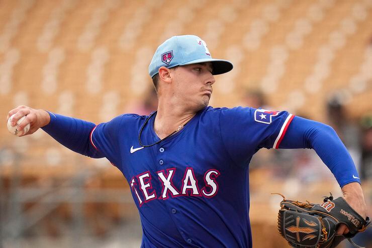 Texas Rangers pitcher Cole Winn delivers during the first inning of a spring training game...