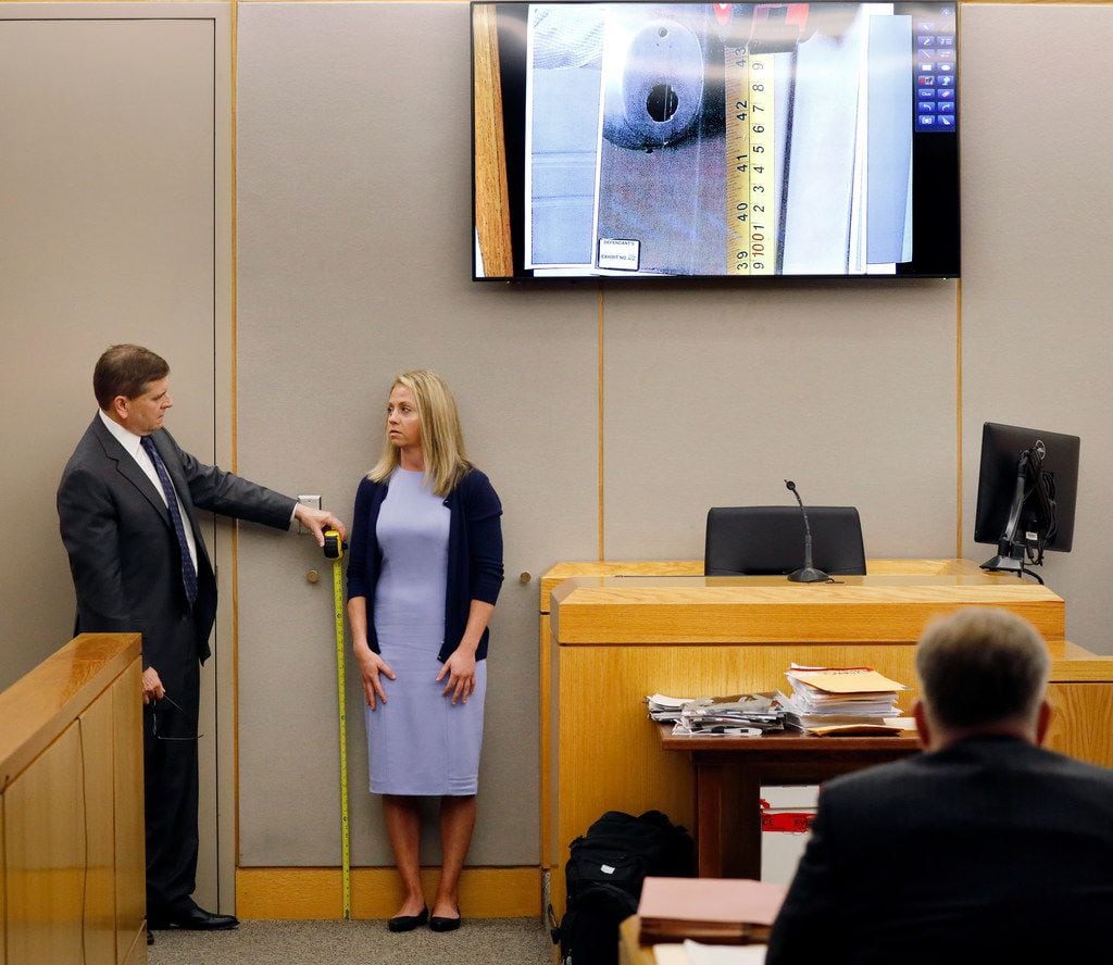 Defense attorney Toby Shook measures the height of a keyhole beside Amber Guyger during...