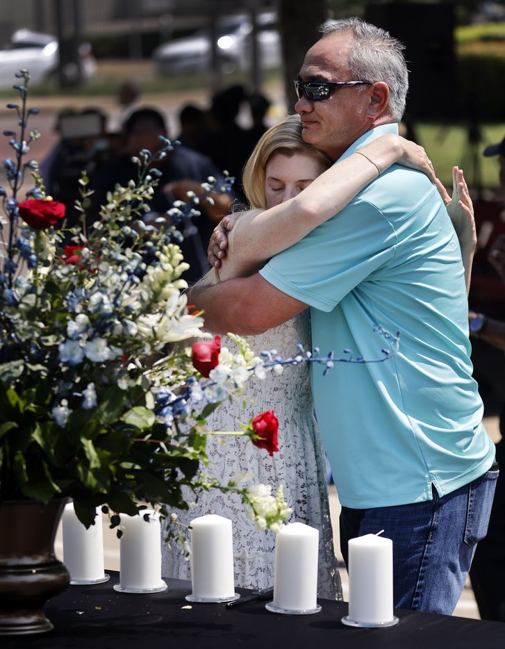 Heidi Smith, widow of fallen Dallas police Sgt. Michael Smith, hugs Michael's brother, Billy Smith, after the two prayed and lit a candle in his honor during the annual Police Memorial Day at the Dallas Police Memorial in downtown Dallas, Wednesday, July 7, 2021.  Smith was one of the officers remembered on the fifth anniversary of the July 7th ambush. (Tom Fox/The Dallas Morning News)