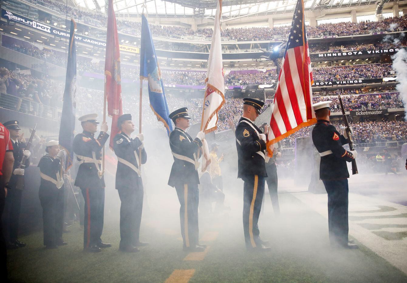 The color guard waits for the smoke to clear so the NFL can honor military members with a...