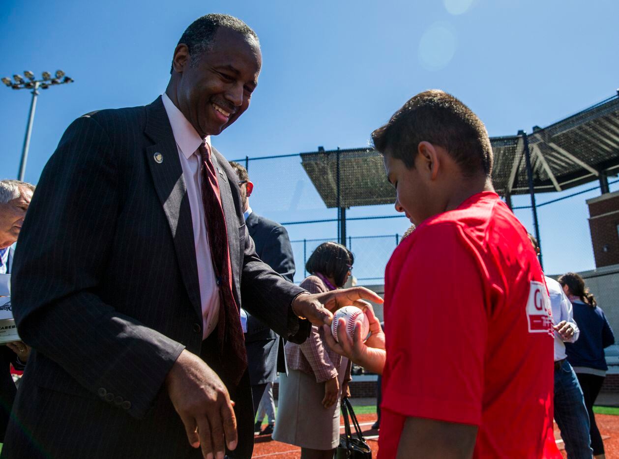 U.S. Secretary of Housing and Urban Development Ben Carson, left, gives an autographed...
