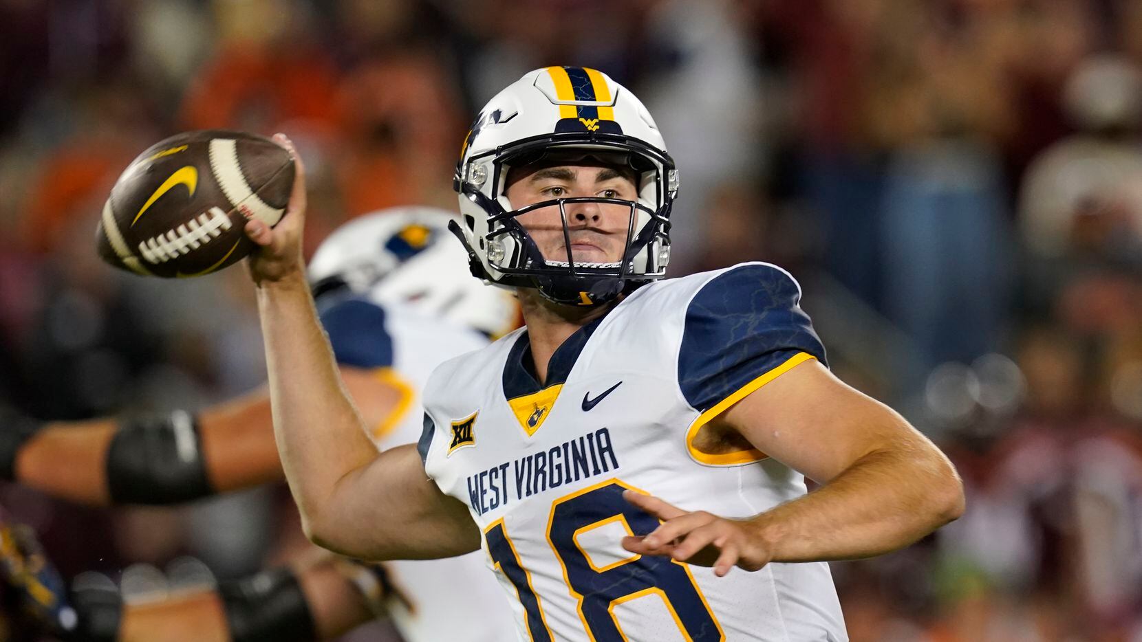 West Virginia quarterback JT Daniels (18) looks to pass during the first half of the team's...