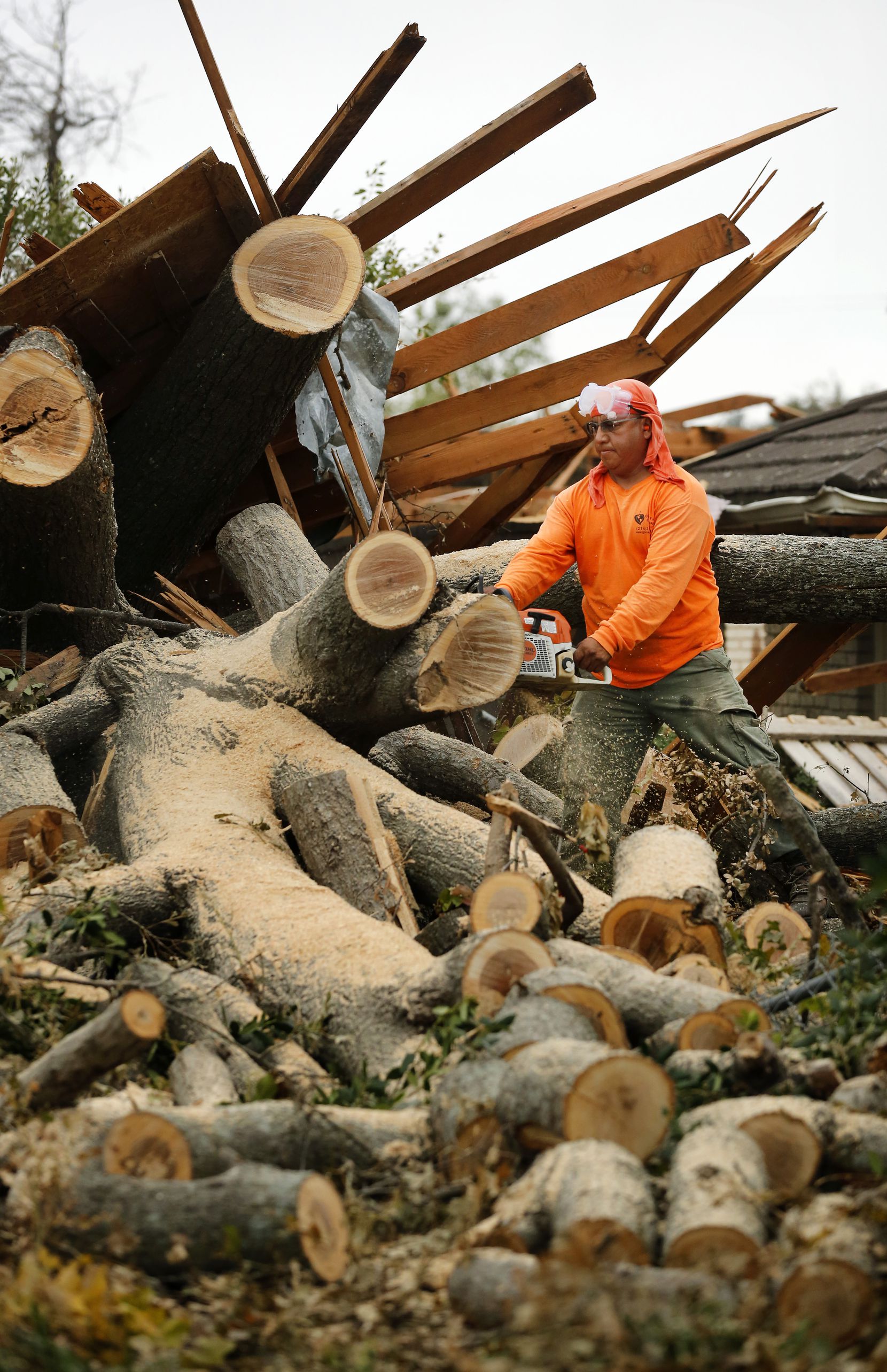 Landscaper Bartolo Bautista used a chainsaw to remove a toppled tree from a home on...