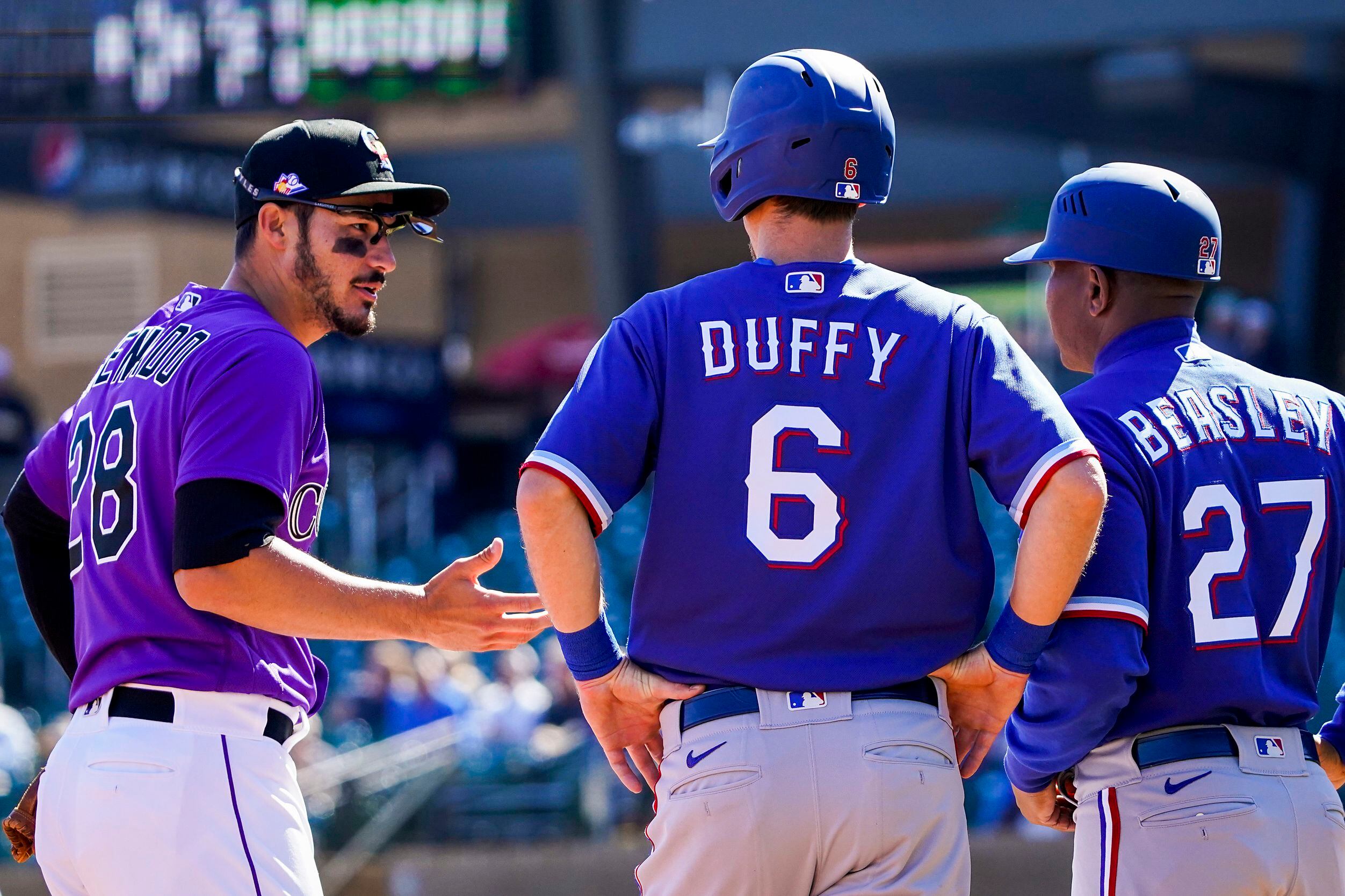 Colorado Rockies third baseman Nolan Arenado chats with Texas Rangers infielder Matt Duffy...