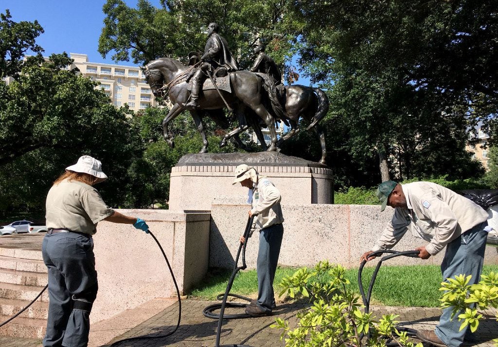 Dallas Parks department workers packed up after removing graffiti from the Robert E. Lee...