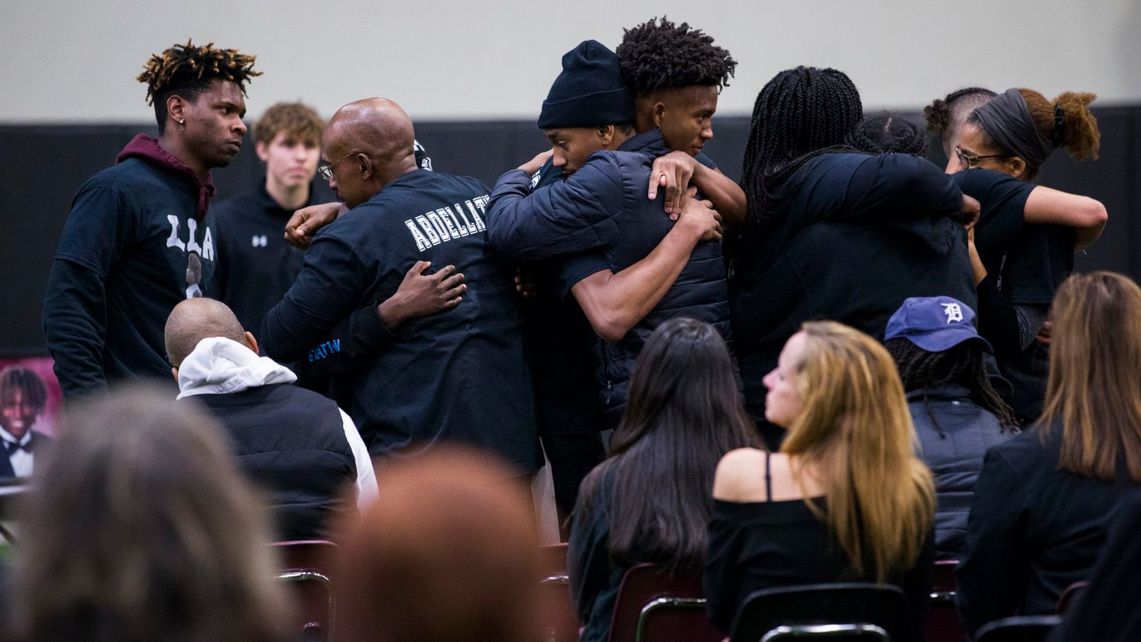 Student athletes hug members of the Abdellatif family during a vigil for Wylie High School...