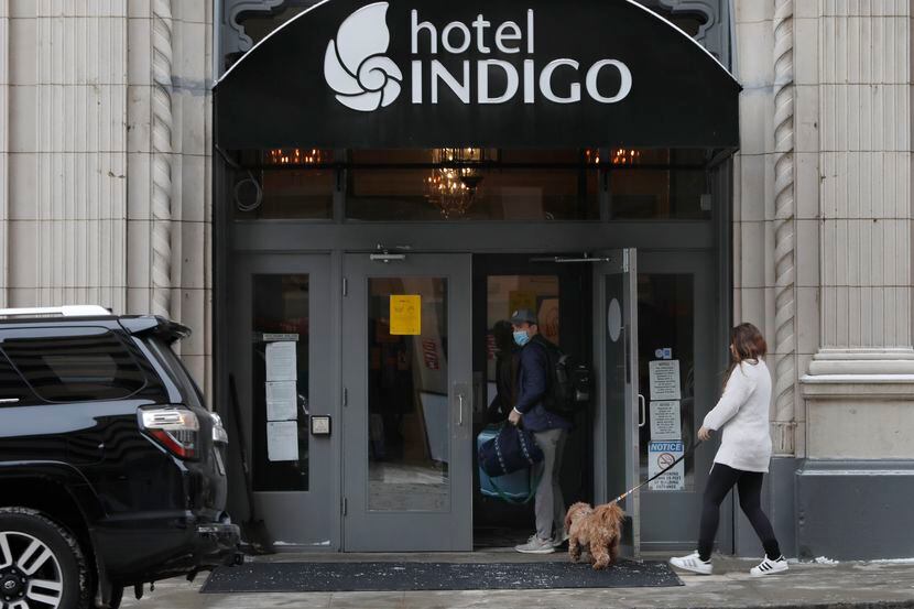 Reid Frye sostiene la puerta a su esposa Taylor y su perro Harlow en el Hotel Indigo en el...