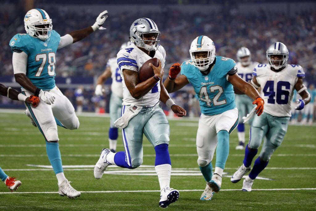 Dallas Cowboys quarterback Dak Prescott (4) runs past Miami Dolphins' Terrence Fede (78) and Spencer Paysinger (42) into the end zone for a touchdown in the first half of an NFL preseason football game, Friday, Aug. 19, 2016, in Arlington, Texas. (AP Photo/Ron Jenkins)