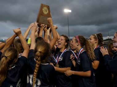 Lewisville Flower Mound players celebrate with the trophy after their UIL 6A girls State...