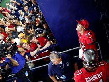 Tampa Bay Buccaneers quarterback Tom Brady (12) watches the video board as fans clamor to...