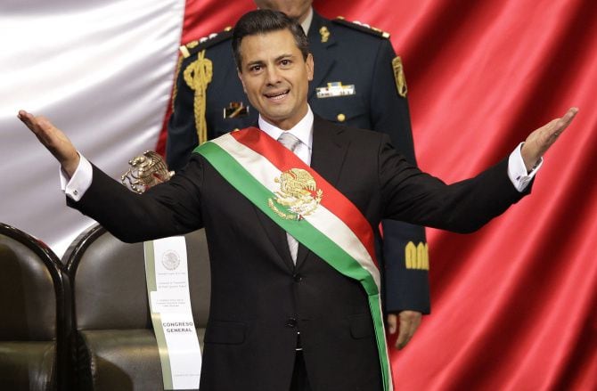 President Enrique Peña Nieto spread out his arms after his swearing-in during Saturday's...