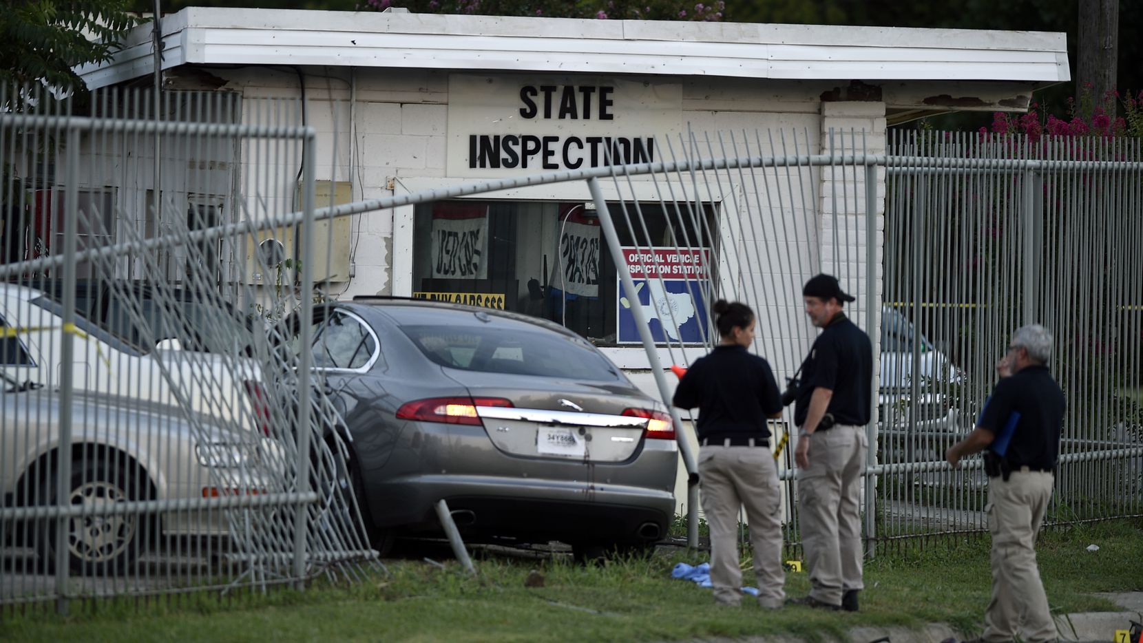 A Denton police investigative team marks and examines items around a Jaguar that crashed...