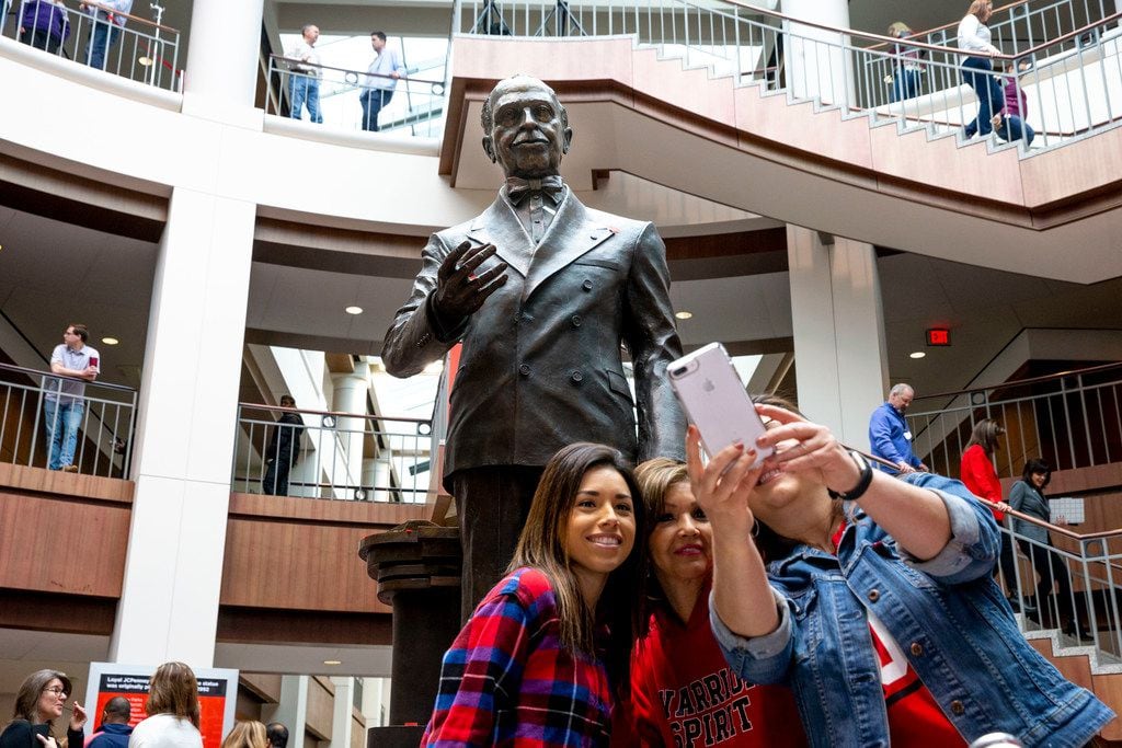 Employees take pictures with the statue of James Cash Penney following its unveiling in the...