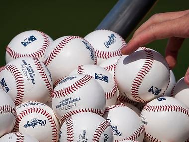 A player reaches into a basked of baseballs  during the Texas Rangers first minor league...