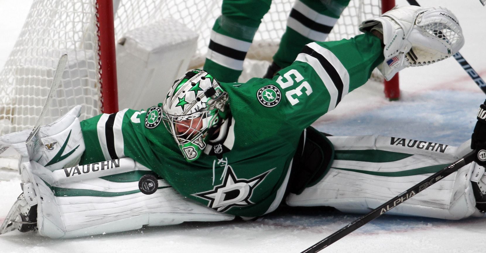 Dallas Stars goalie Anton Khudobin (35) gets a close look at the puck as he stretches out to...