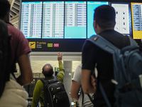 Passengers check their flight schedules at Tocumen International Airport in Panama City on...