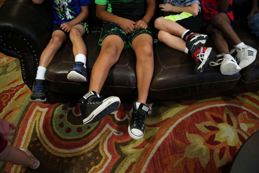 Boys sit on the couch at Jonathan's Place, which serves abused and neglected children, in...