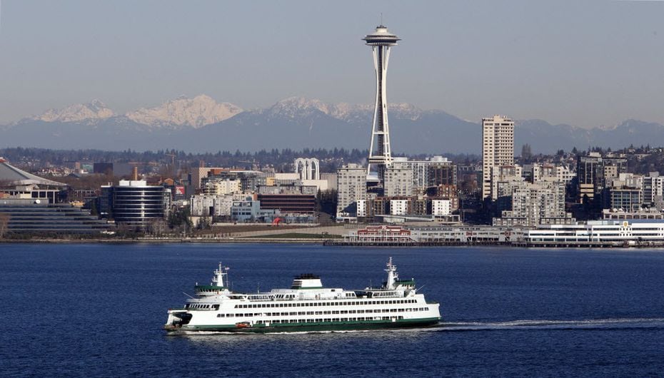 With the Cascade Mountains as a backdrop, a ferry sets sail across Elliott Bay out of...