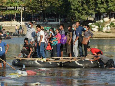 Personas en una balsa cruzan el Río Suchiate que separa Guatemala y Ciudad Hidalgo, Chiapas, México.