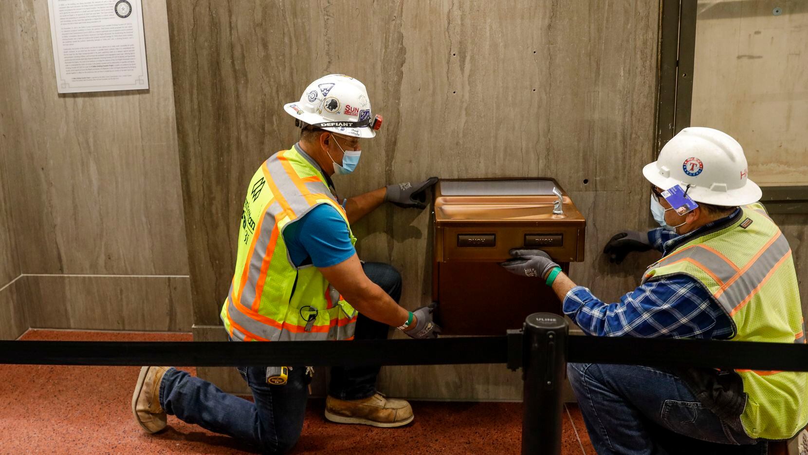 Saul Fuentes and Mario Vilatoro fit a segregation-era water fountain before it is sent for...