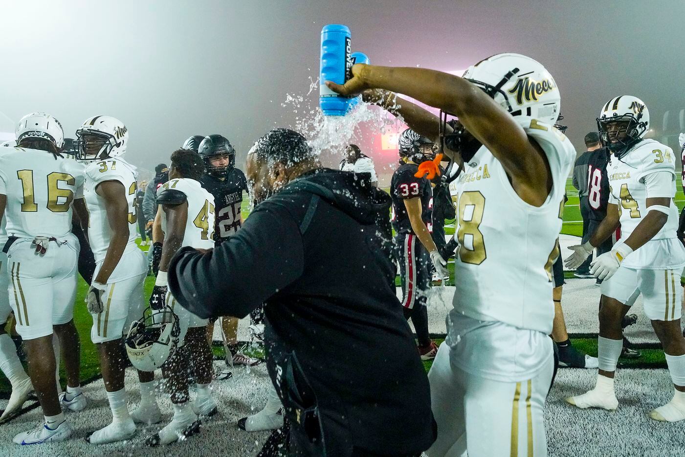 South Oak Cliff’s Izale Williams (28) douses a coach with water bottles following a victory...
