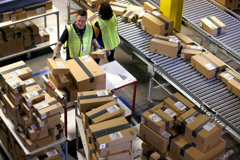 FILE - In this Monday, Dec. 2, 2013, file photo, Amazon.com employees organize outbound packages at an Amazon.com Fulfillment Center on "Cyber Monday" the busiest online shopping day of the holiday season in Phoenix. Amazon announced Wednesday, March 9, 2016, it has finalized an agreement to lease 20 Boeing jets from Air Transport Services Group as it builds out its delivery capabilities. (AP Photo/Ross D. Franklin, File)