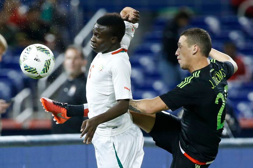 El mexicano Jesús Dueñas (20) y el senegalés Elimane Oumar Cisse (6) disputan un balón en el...