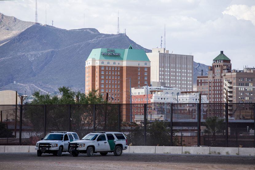 Dos patrulleros del otro lado del Río Grande con la ciudad de El Paso de fondo.