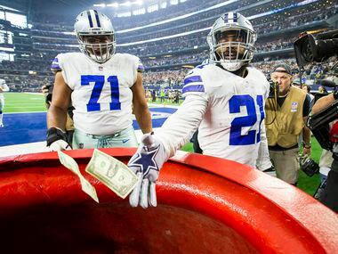 Dallas Cowboys running back Ezekiel Elliott (21) drops $21 into the Salvation Army kettle...