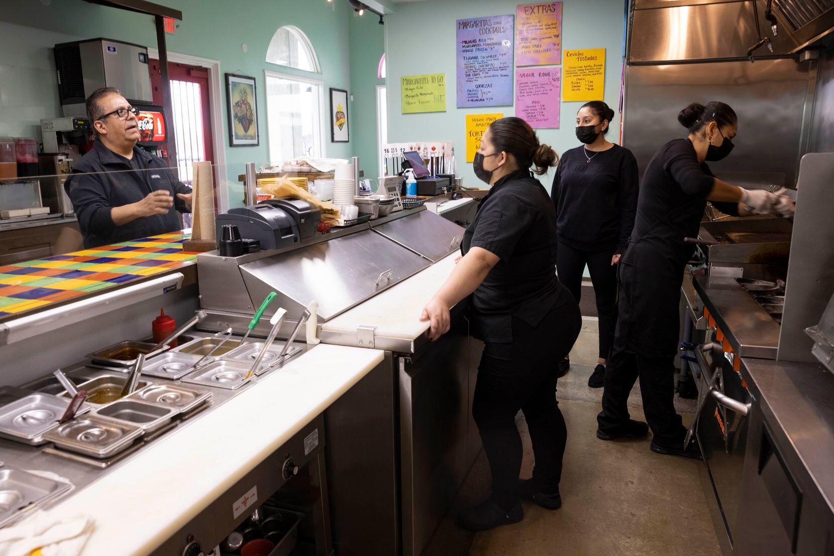 Jesús Carmona (left), owner of Milagro Tacos Cantina, talks to employees at his restaurant...