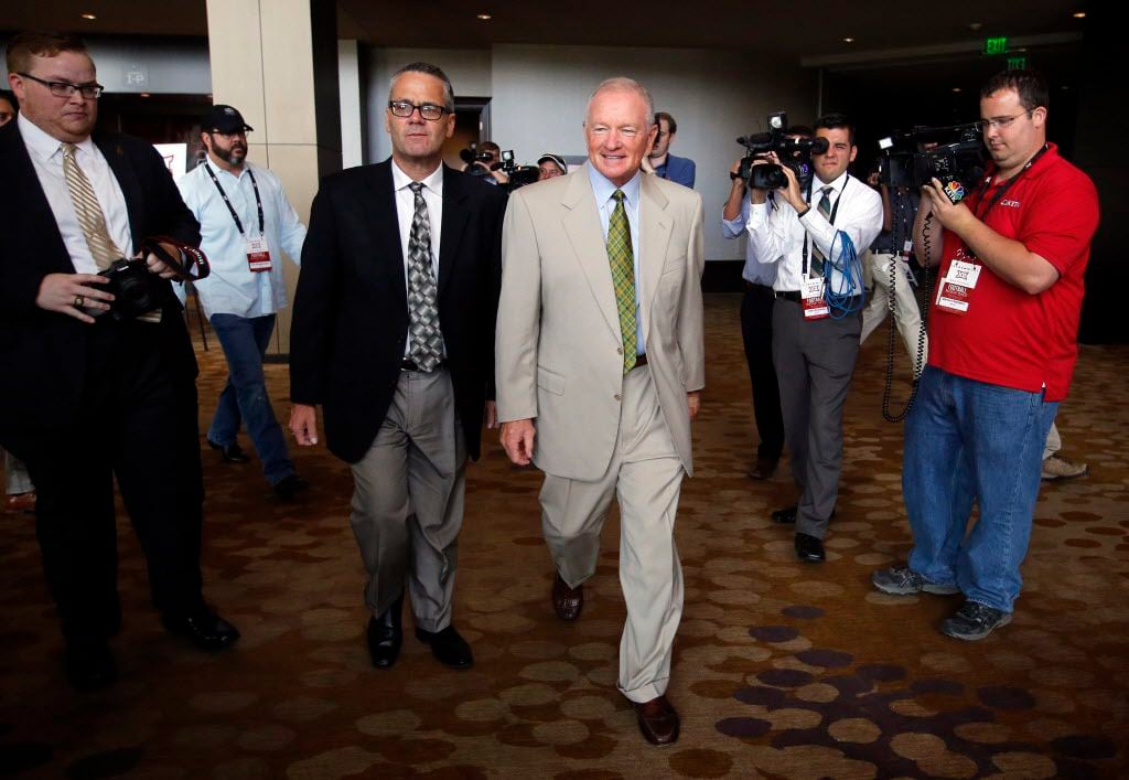 New Baylor head football coach Jim Grobe (center, right) is escorted out of the Big 12...
