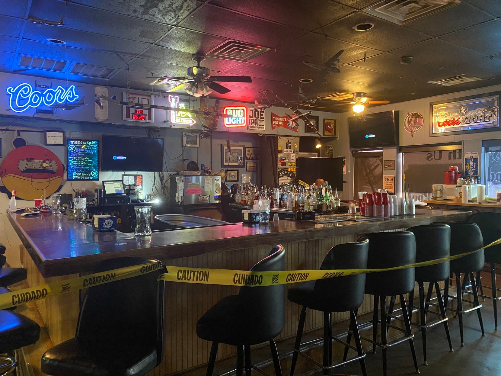 Yellow caution tape blocked off bar stools at Cockpit Bar in northwest Dallas on Friday.