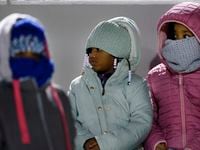 A trio of youngMansfield Timberview fans are bundled up against the cold as their team faced...