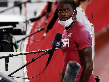 USA’s Trayvon Bromell watches the replay of his race before answering questions from the...