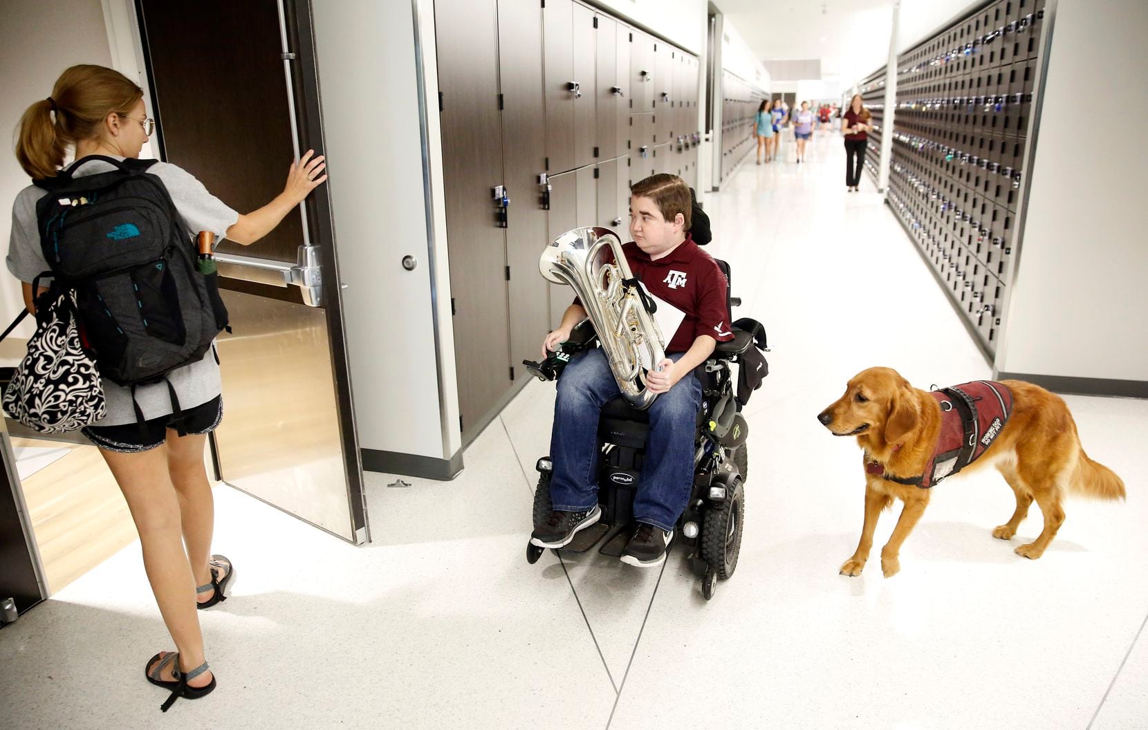 Texas A&M graduate student Kyle Cox, who has Duchenne muscular dystrophy, and his golden...