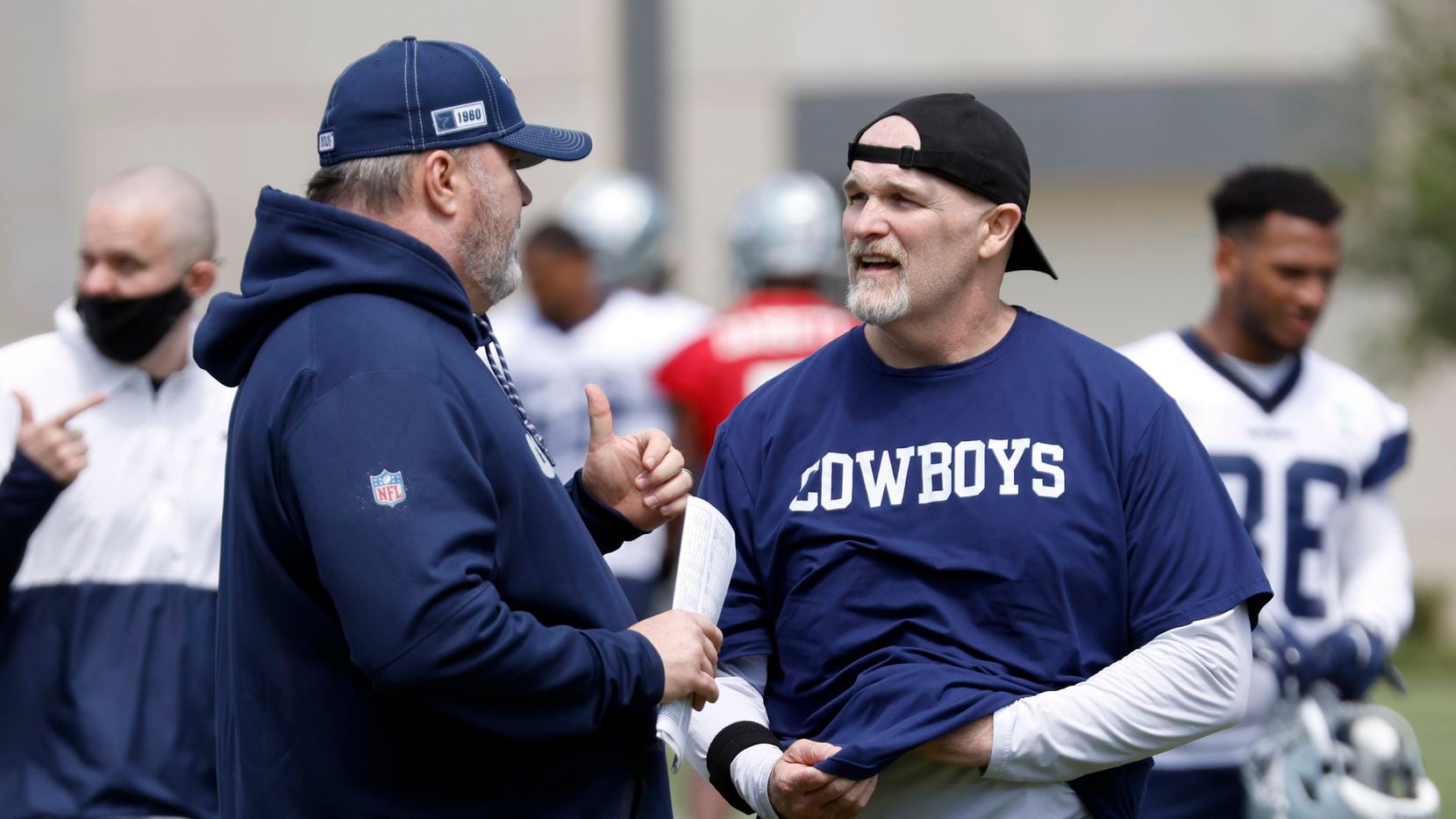 Dallas Cowboys head coach Mike McCarthy (left) visits with defensive coordinator Dan Quinn...