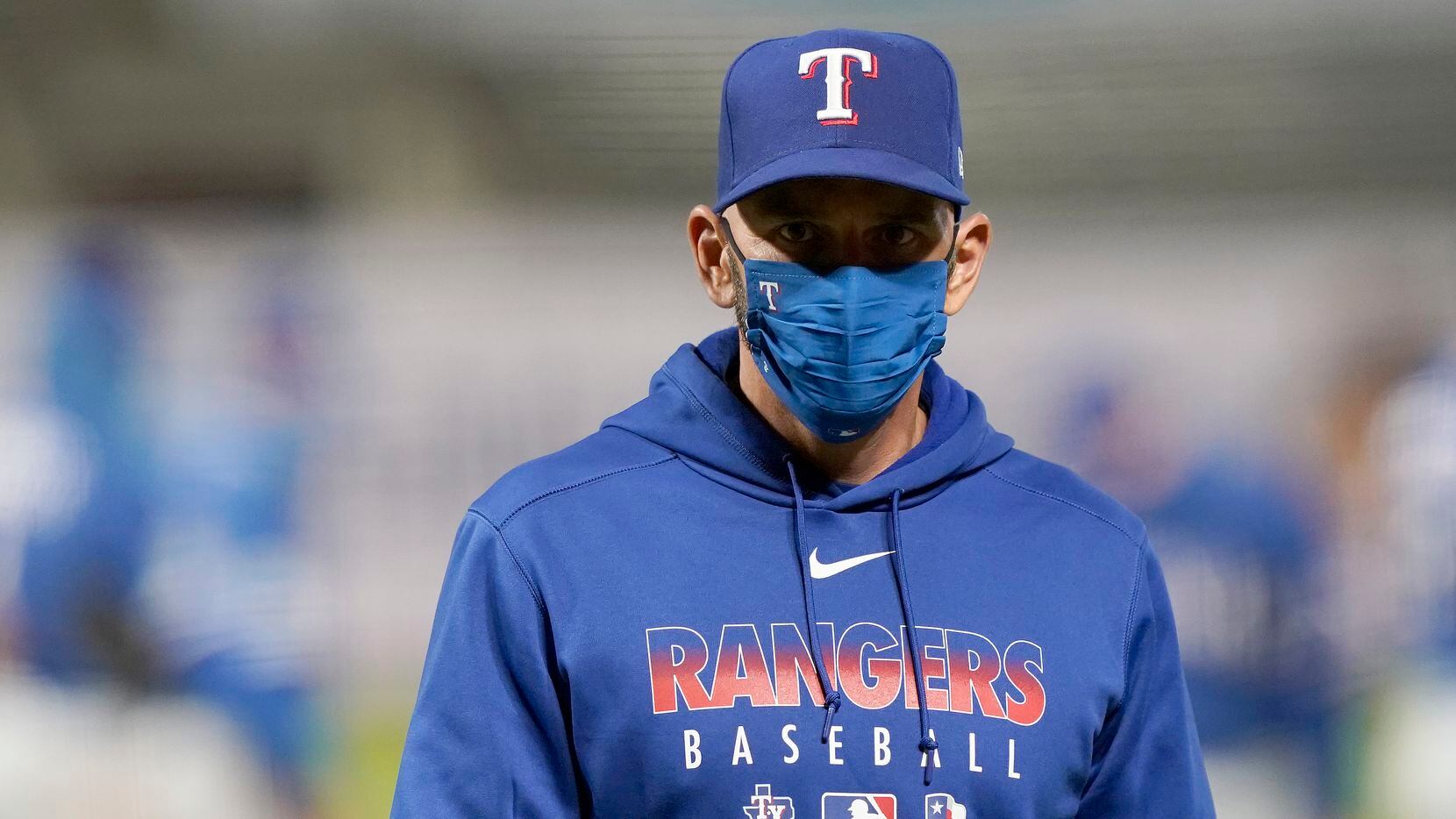 Manager Chris Woodward #8 of the Texas Rangers walks back to the dugout after making a...