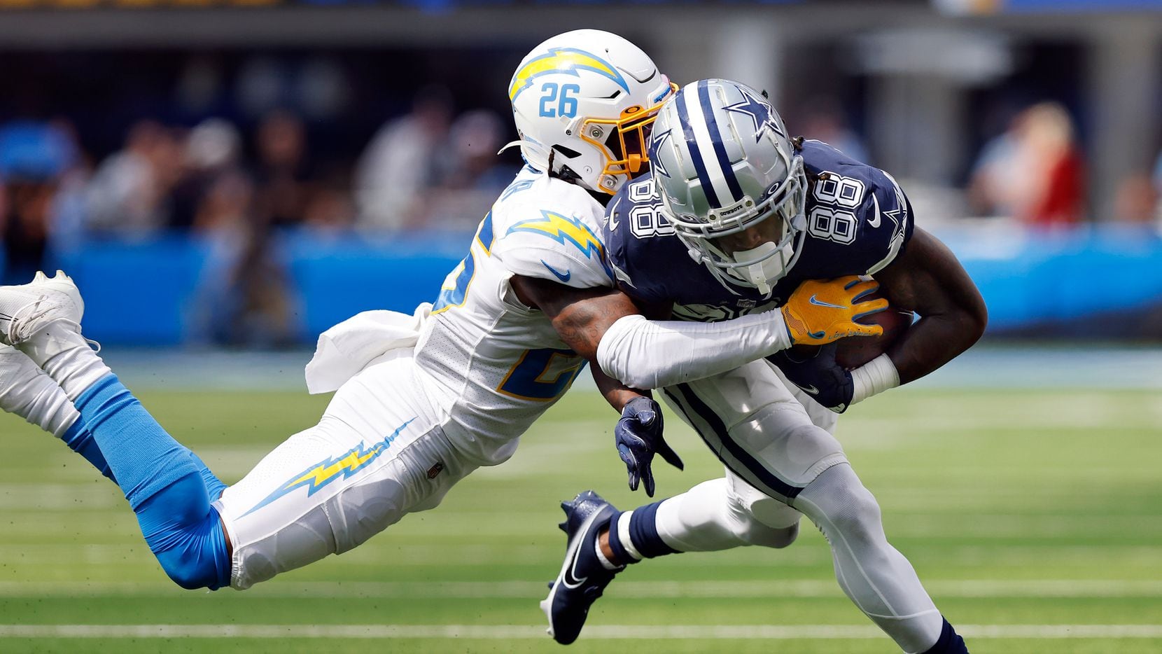 Dallas Cowboys wide receiver CeeDee Lamb (88) is brought down by Los Angeles Chargers...