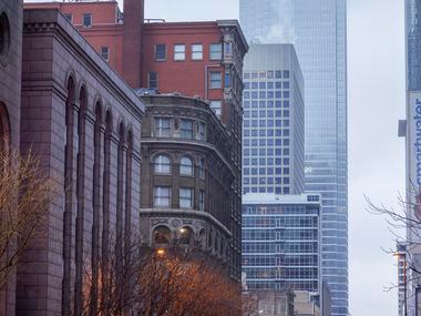 The Bank of America tower disappears in a haze of freezing rain as motorists drive along Elm...