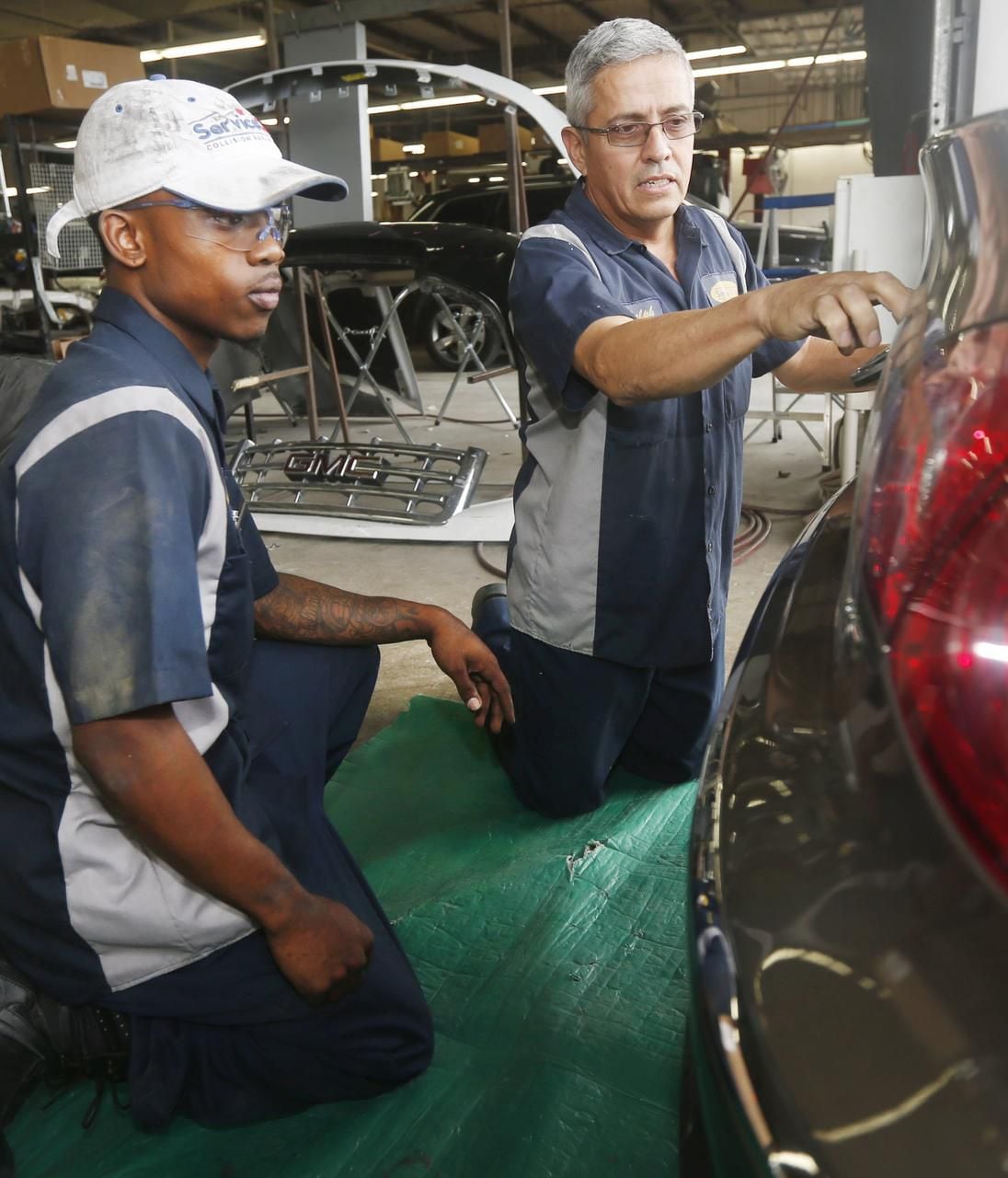 Supervisor Ralph Gonzales  (right) inspects the work of apprentice Kenneth Buford at the...
