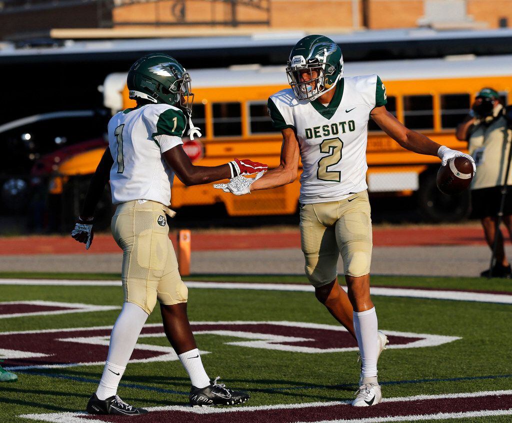 Desoto's Jordan Brown (1) and Lawrence Arnold (2) slap hands after Arnold's touchdown catch...