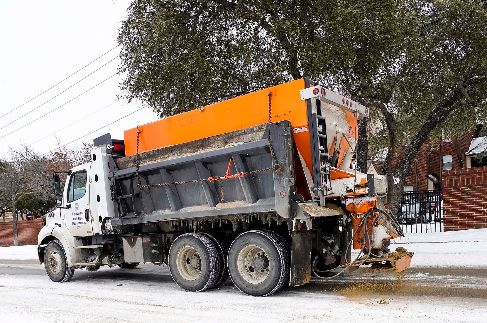 A City of Dallas truck spreads de-icing materials on Walnut Hill Lane near North Central Expressway on Tuesday.